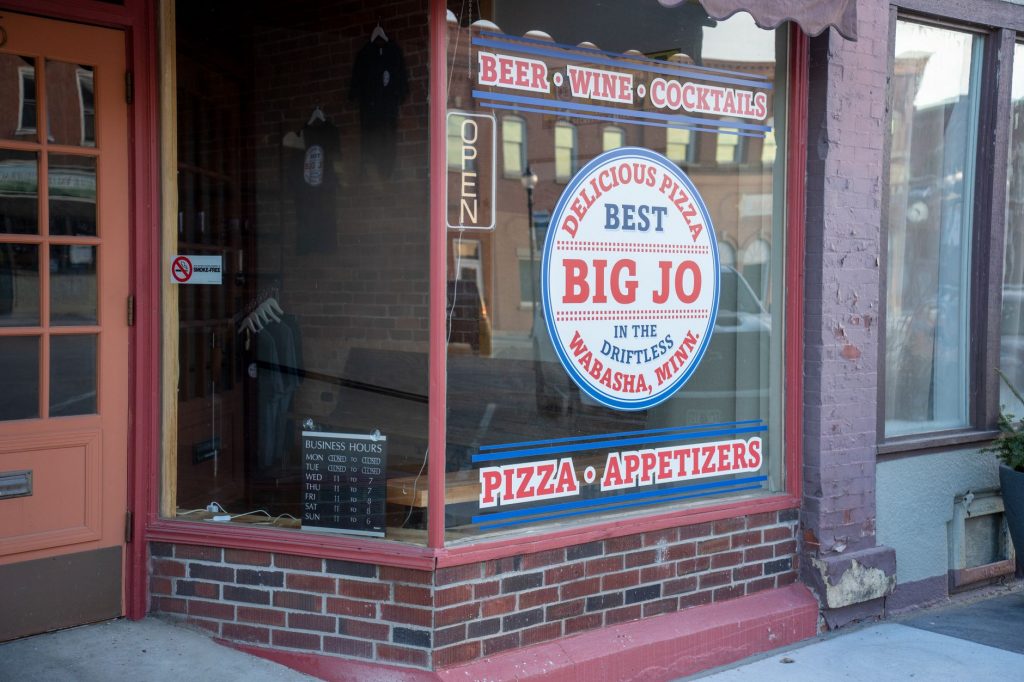 Charming storefront of Big Jo's Pizza in Wabasha, MN, displaying beer, wine, and appetizers.