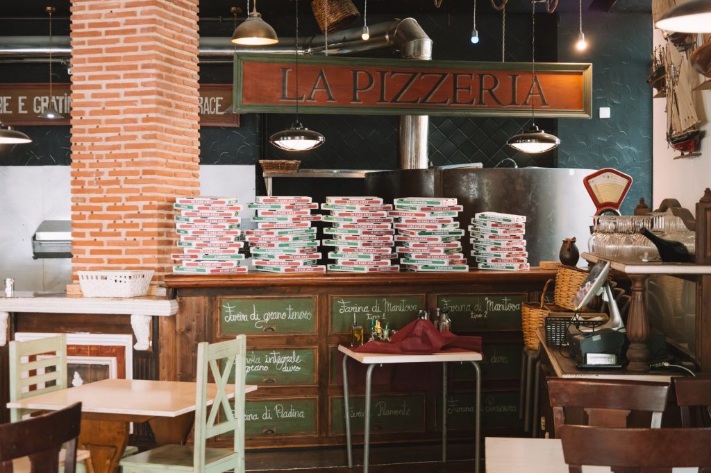 Cozy pizzeria interior with stacked pizza boxes and rustic decor in Valencia, Spain.