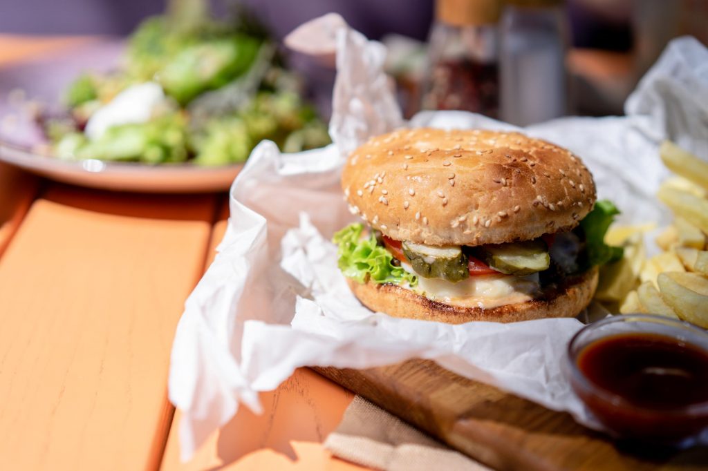 Delicious burger with fresh salad and fries on a sunny day.