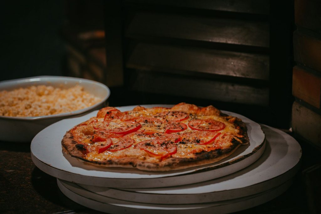 Delightful freshly baked homemade pizza with tomato slices and cheese, perfect for a cozy evening meal.