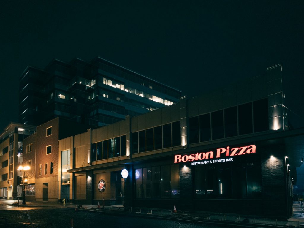 Illuminated Boston Pizza restaurant facade at night in St. John's, Newfoundland, Canada.