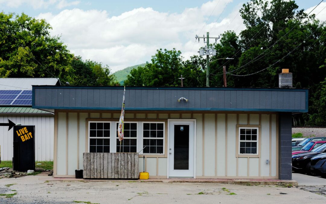 A small rural bait shop with live bait sign, solar panels, and surrounding greenery.