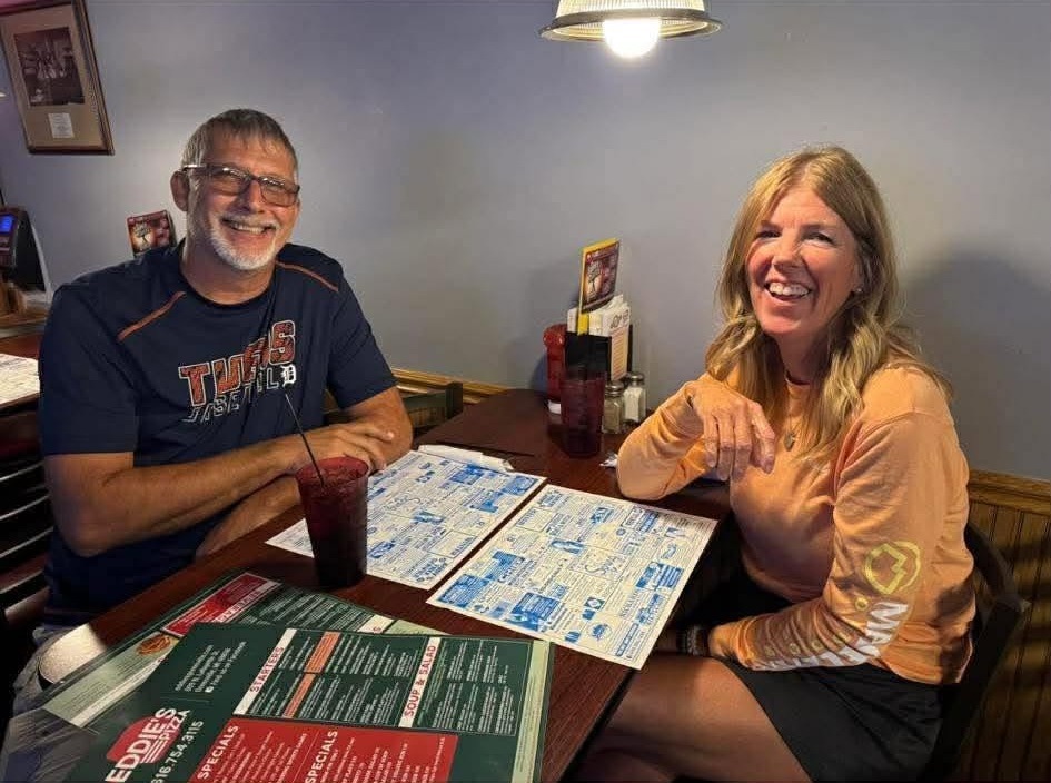 Two smiling guests at a table at Eddie's of Greenville